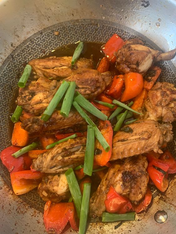 Step 1.1: Return cooked chicken wings, add spring onions and toss cooking over medium-high heat until the wings absorb the sauce and char slightly