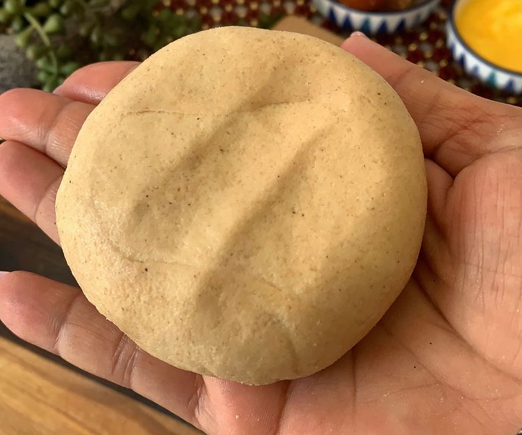 Step 2.3: Brush ghee on the rolled dough, place stuffing in the centre, fold the edges to cover, and gently roll into a circular shape