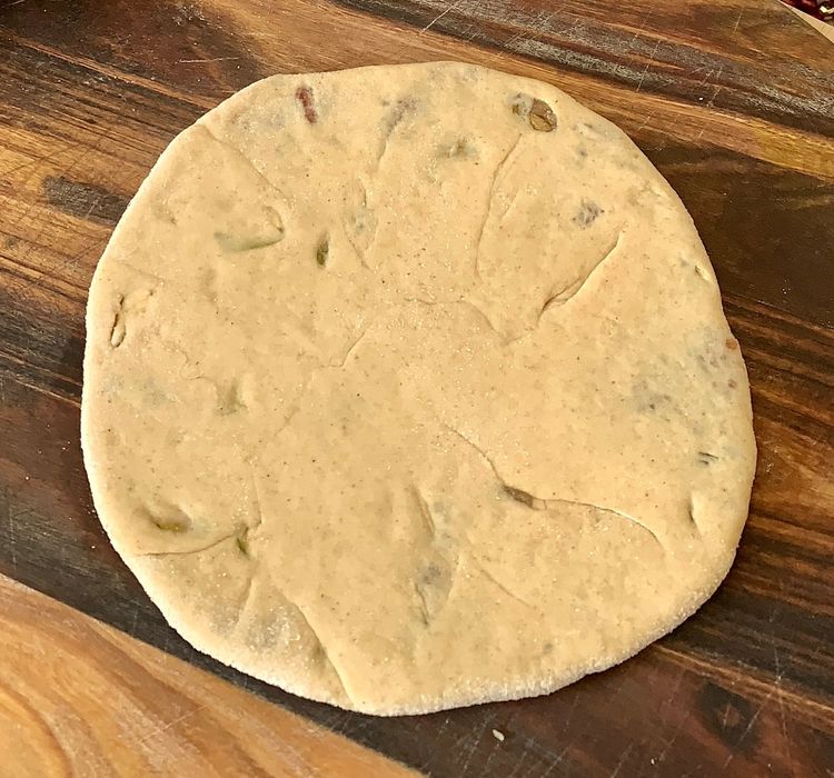 Step 2.4: Brush ghee on the rolled dough, place stuffing in the centre, fold the edges to cover, and gently roll into a circular shape