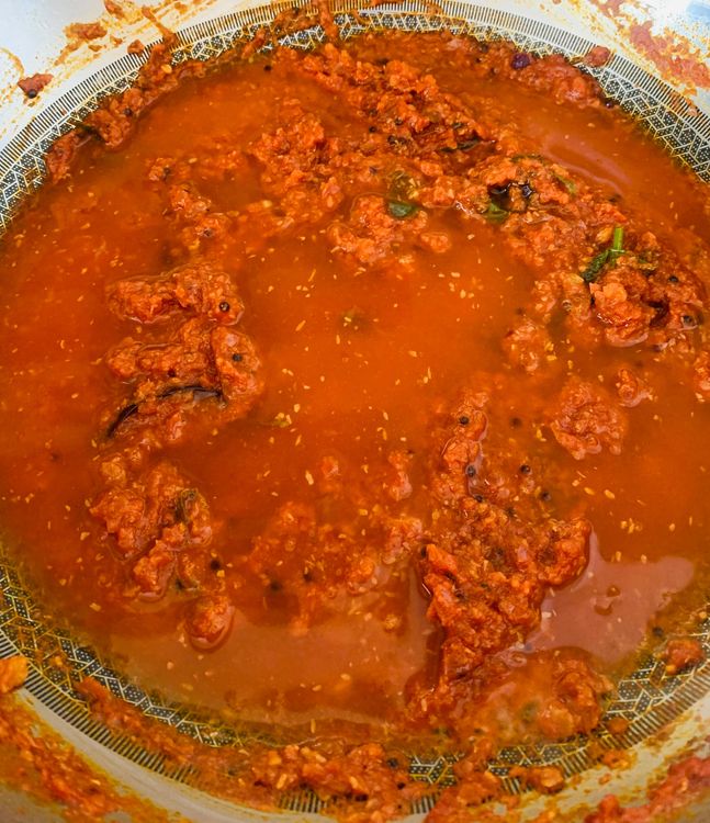 Step 2.1: Add water, bring it to a boil, cover, and simmer for 4-5 minutes on medium heat until oil starts to ooze to the sides
