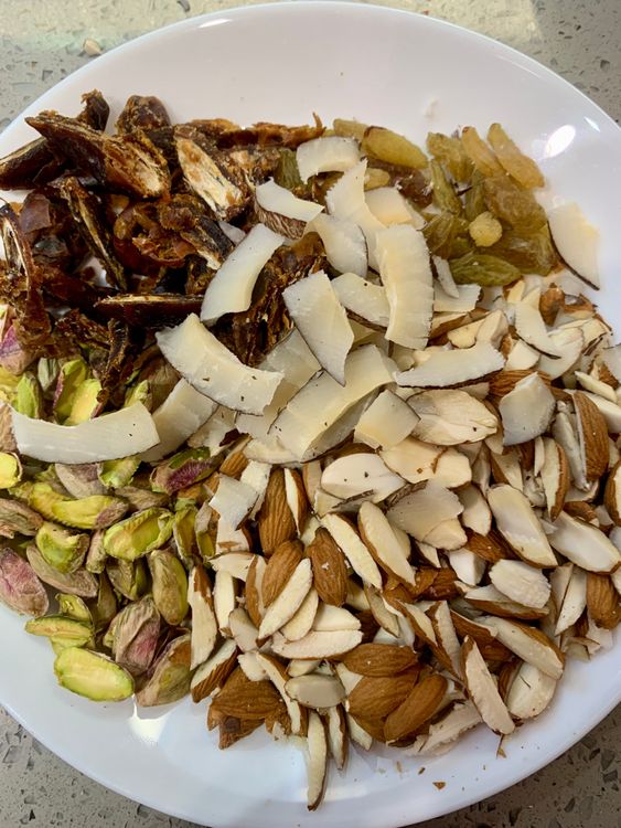 Step 1.1: Add the chopped dates, almonds, pistachios, sliced dry coconut, and raisins and fry for a few minutes until lightly golden