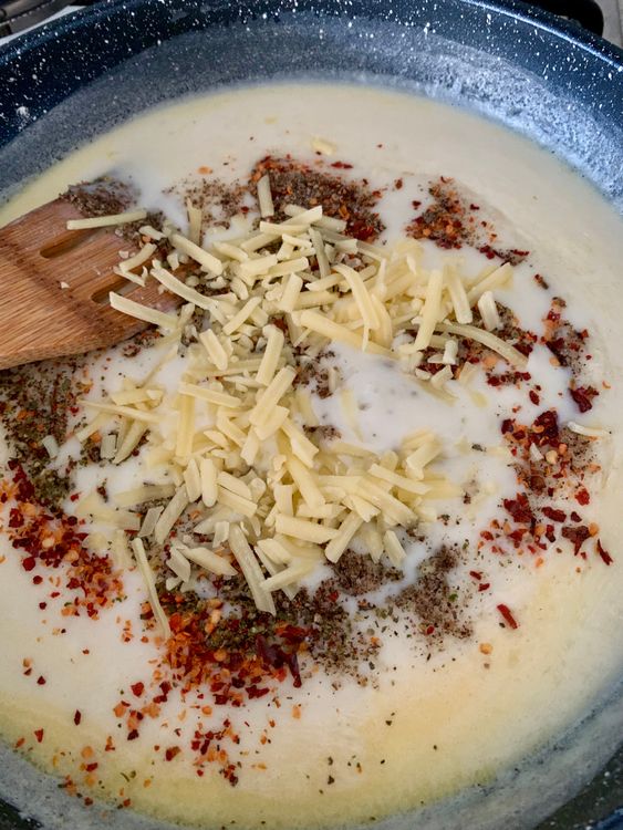 Step 3.1: Stir in salt, black pepper, mixed herbs or oregano, chilli flakes (if using), and cheese