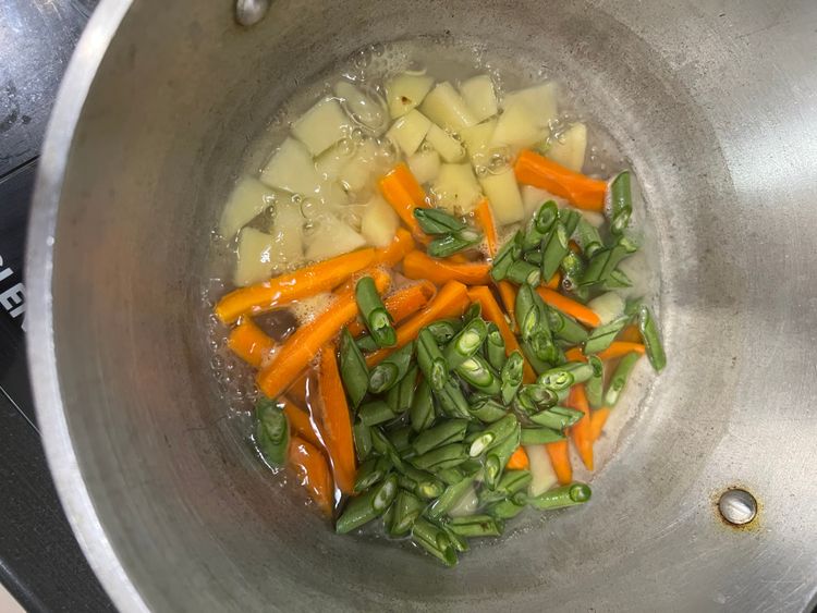 Step 1.2: In a pot, add the mixed vegetables, turmeric powder, salt, and water to just cover the vegetables and boil