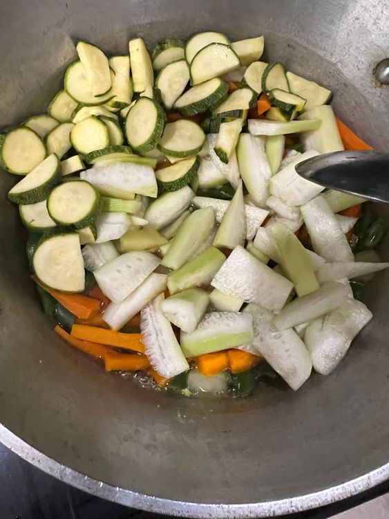 Step 1.1: Add the hard vegetables that take longer cooking time first, followed by softer veggies like gourd and zucchini later