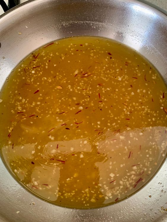Step 4.1: Gradually pour the prepared sugar syrup into the roasted poha, stirring continuously to avoid lumps