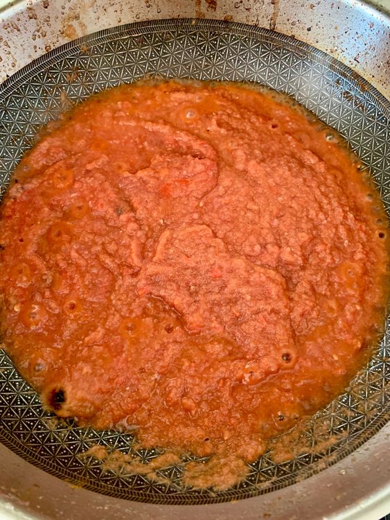 Step 2.2: Stir in the ground tomatoes and cook for 4–5 minutes until the oil begins to separate