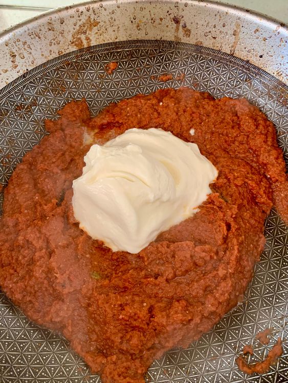 Step 2.1: Lower the heat and add whisked curd and slit green chillies