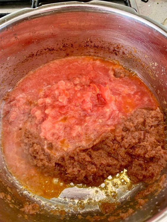 Step 3.1: Pour in the tomato puree and cook until the oil starts to separates from the masala