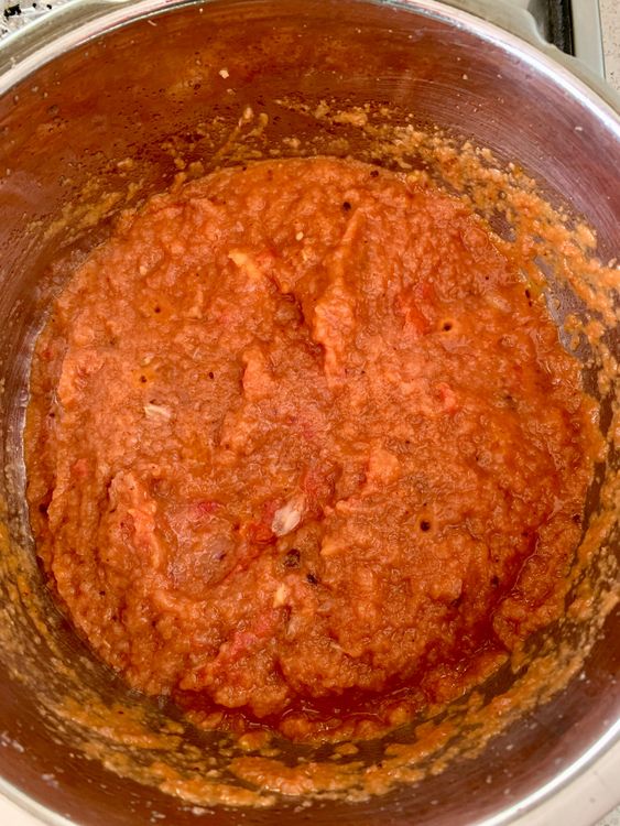 Step 3.2: Pour in the tomato puree and cook until the oil starts to separates from the masala