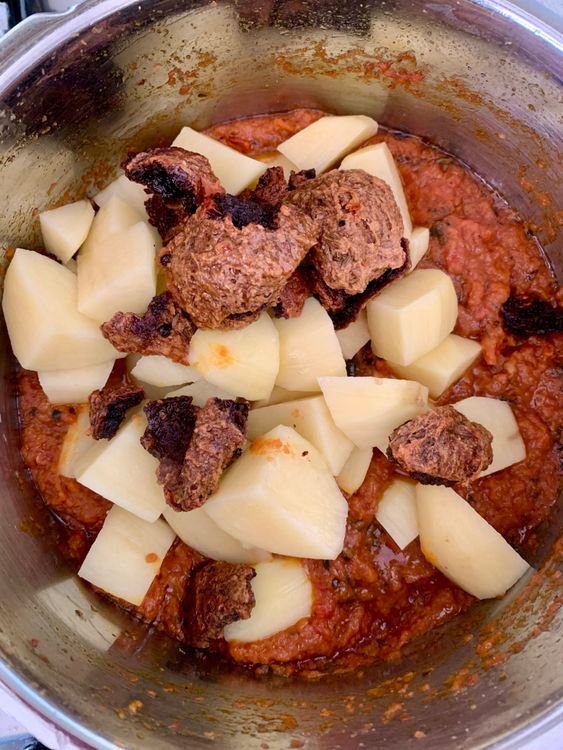 Step 4.1: Add the fried wadiyan and potato cubes, mixing well to coat them in the masala