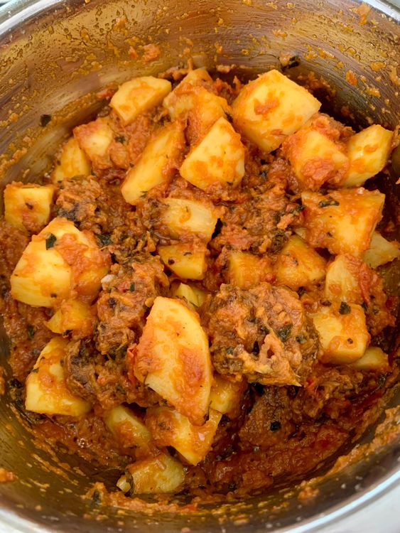 Step 4.2: Add the fried wadiyan and potato cubes, mixing well to coat them in the masala