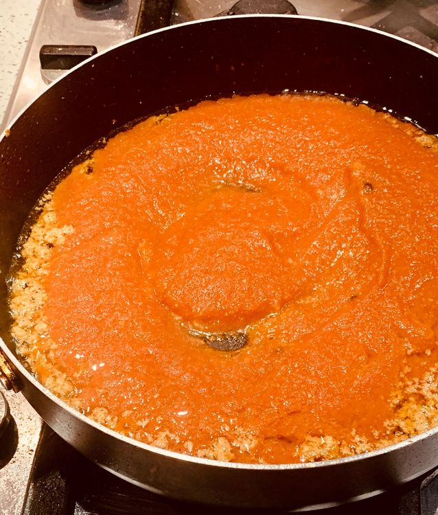 Step 1.1: Add ground tomatoes to the wok, stir and cook for 4-5 minutes until the oil separates