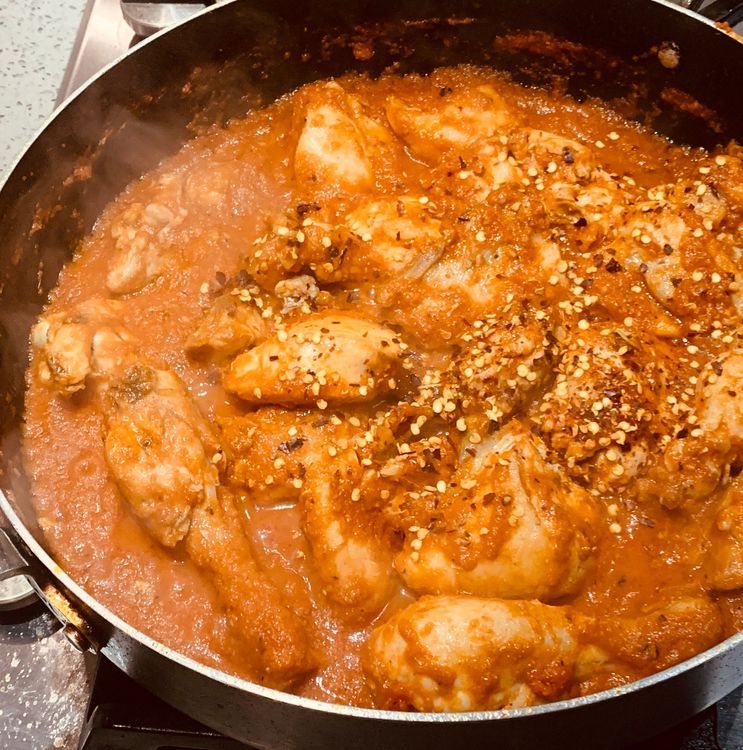 Step 1.2: Add the fried chicken pieces and chilli flakes to the wok and mix them to combine with the tomato gravy