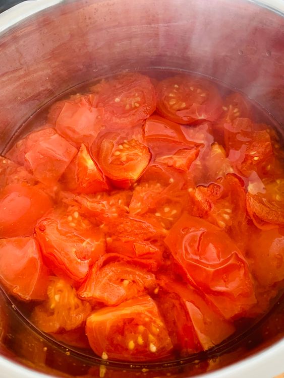 Step 2.2: In a pressure cooker, add the tomatoes with 1 cup of water
