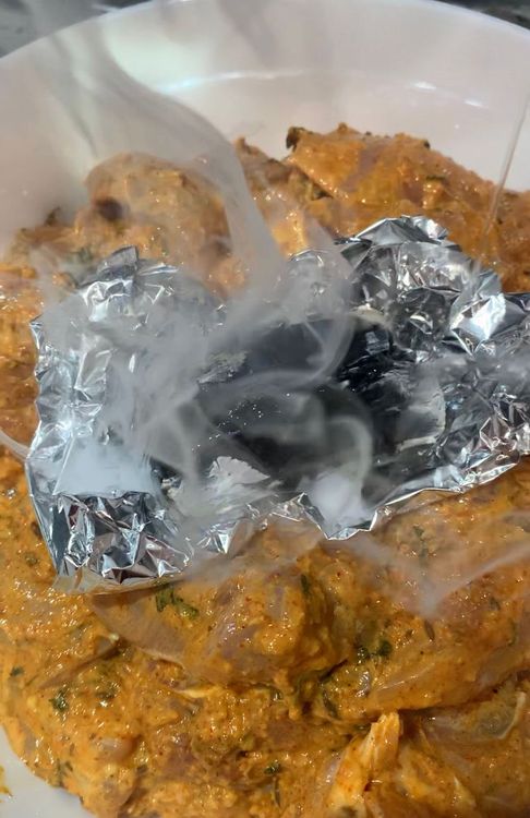 Step 1.1: Place a piece of aluminium foil in the centre of the marinated chicken bowl and put the hot coal on it