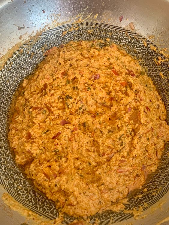 Step 4.2: Pour in the curd-spice mix and cook on medium heat, stirring continuously, until the oil starts to separate and the masala thickens
