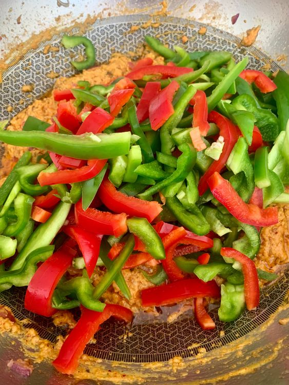 Step 5.1: Add the sliced capsicum and toss well to coat with the masala
