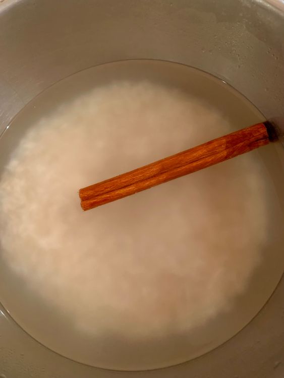 Step 1.1: In a large bowl or container, combine the rinsed rice, hot water, and cinnamon stick (or ground cinnamon)