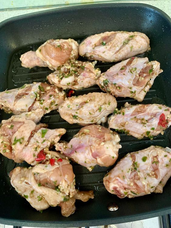 Step 1.1: Place the marinated chicken wings on the grill pan, cooking for about 8-10 minutes per side until they're cooked through and develop a nice char