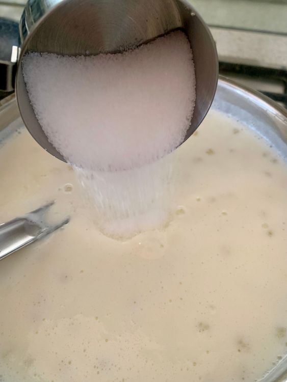 Step 5.1: Add sugar, cardamom powder, and 3 tablespoons of the roasted nuts (reserve 1 tablespoon for garnish), along with saffron strands if using