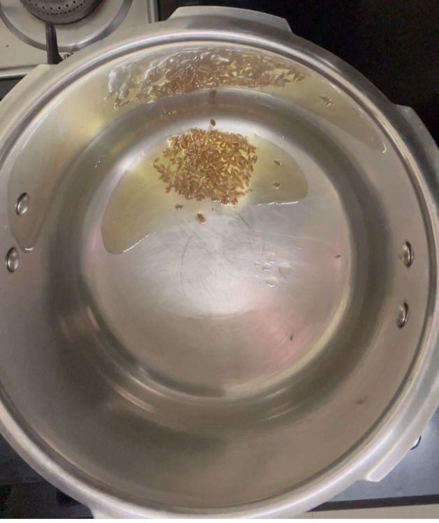 Step 1.1: Take a pressure cooker and add ghee followed by jeera
