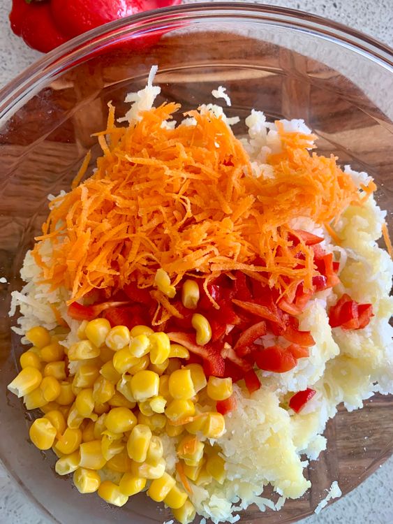 Step 1.1: Add the drained poha, carrot, bell pepper, corn kernels, rice flour, grated cheese, chopped coriander leaves, black pepper powder, cumin powder, garam masala, amchur powder, red chilli flakes and salt