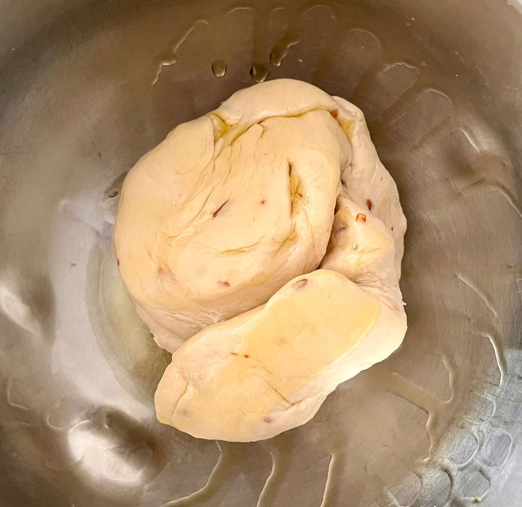 Step 1.1: Take a bowl, oil it with olive oil, then place the dough in it