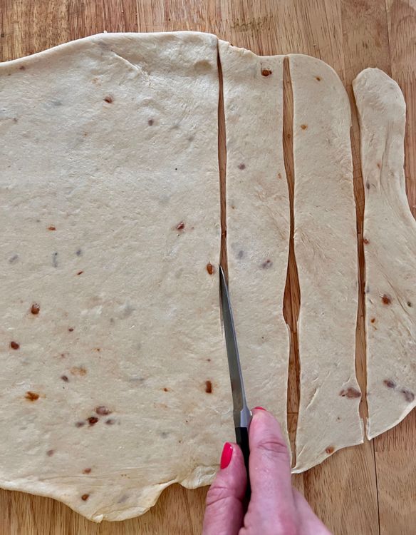 Step 1.1: Next, facing the long edge of the rectangle, cut 1 - 1/2 to 2’ strands of dough
