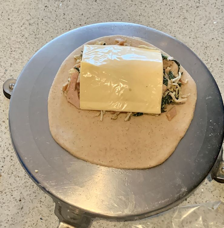 Step 2.1: Add a layer of cheese or a cheese slice onto the mixture and fold the remaining half of the dough over the filling