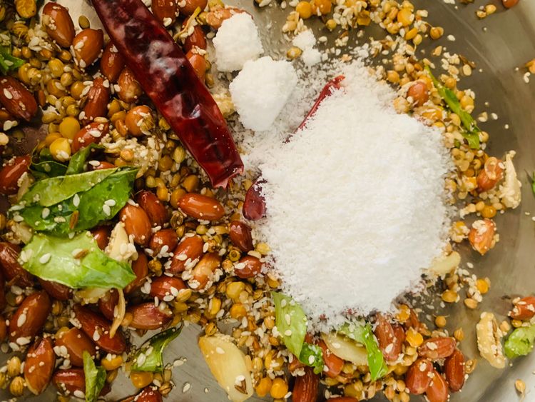 Step 1.1: Add the dry red chillies and desiccated coconut and continue roasting until the coconut turns lightly golden and fragrant