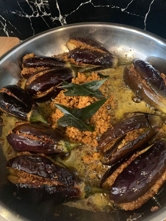 Step 3.1: Push the brinjals to the edges of the pan
