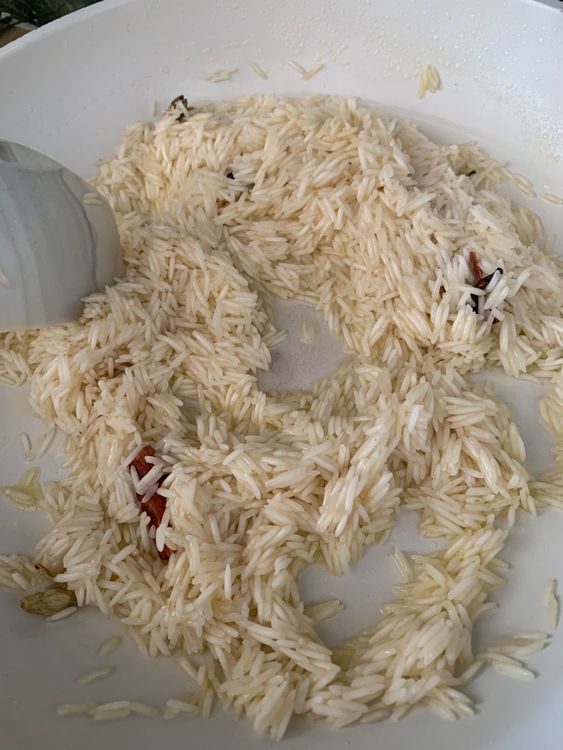Step 2.1: Add the drained rice and stir for a minute to coat the grains with the spiced ghee