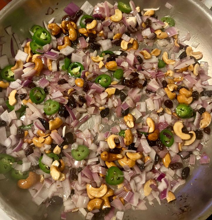 Step 2.2: Next, add the red onion, serrano peppers, cashews, and raisins