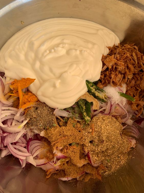 Step 1.1: In a large mixing bowl, add the chicken pieces along with ginger-garlic paste, sliced onions, coriander powder, cumin powder, turmeric, garam masala, green chillies, kasuri methi, salt, brown onions, and whisked curd