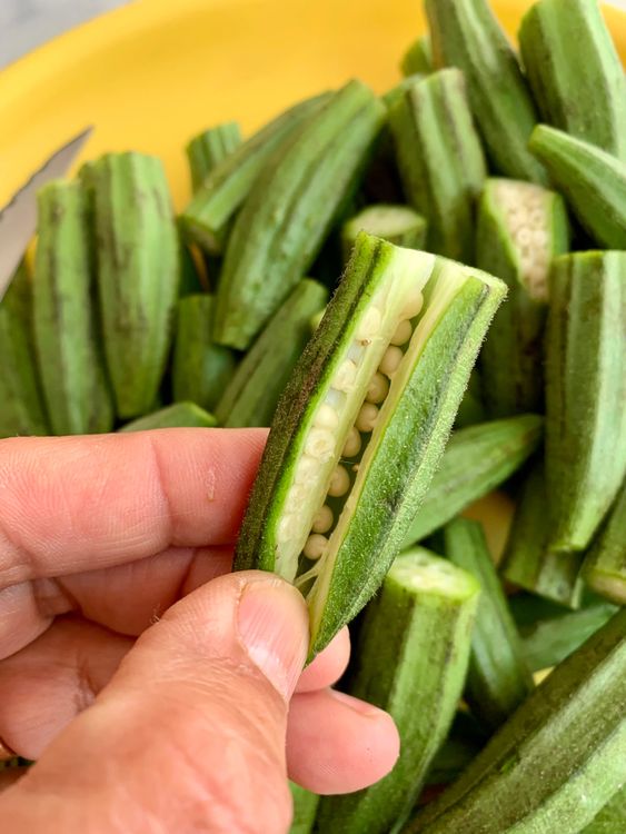Step 1.2: Trim both ends, then make a lengthwise slit in each bhindi—keeping them whole—so they can be stuffed