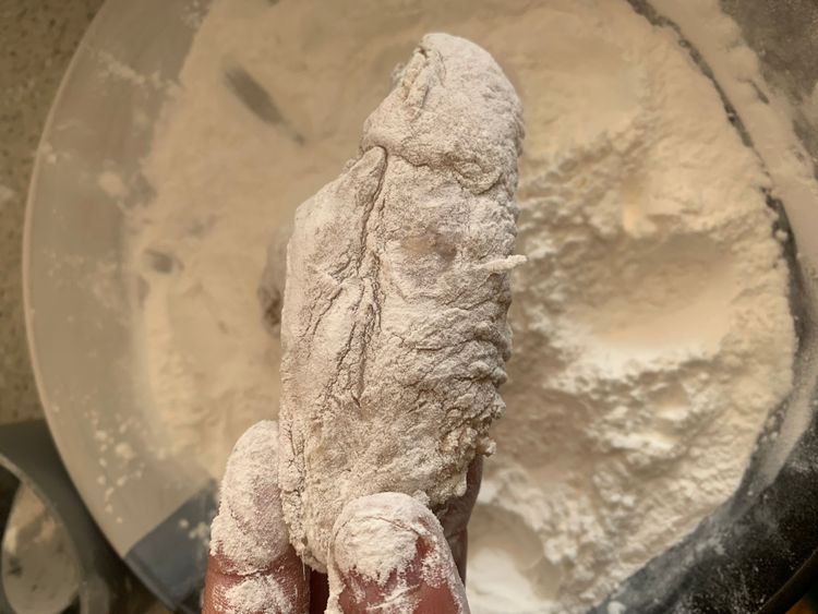Step 3.2: Dredge each marinated wing in the flour mix, shaking off excess