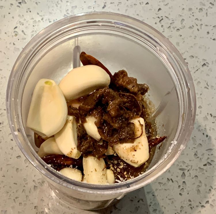 Step 2.1: Combine desiccated coconut, dry red chillies, cumin seeds, coriander seeds, ginger, garlic cloves, tamarind pulp, turmeric, salt and water as required