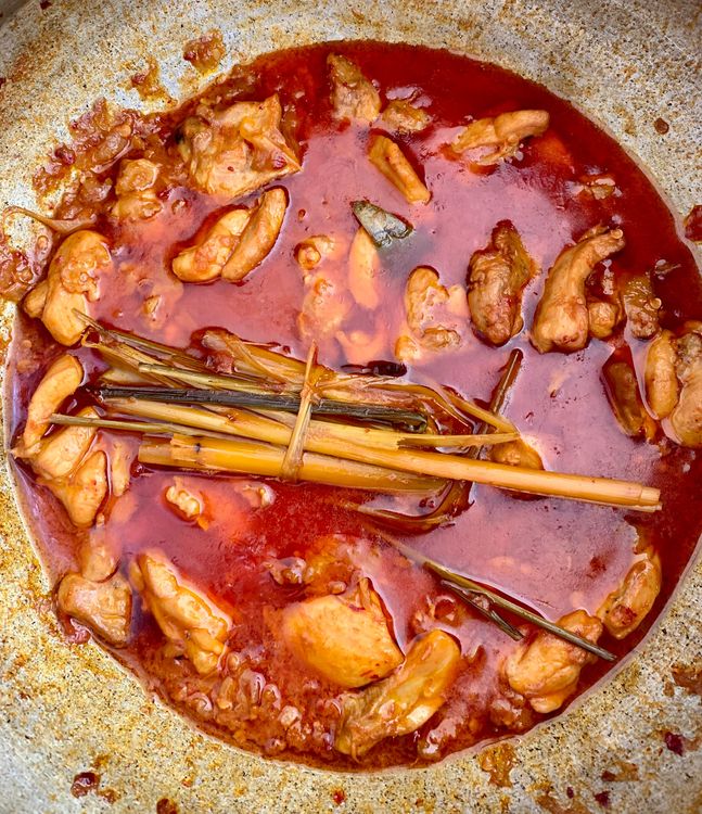 Step 1.1: Pour in a cup of water, cover the wok, and let the chicken simmer for 20-25 minutes or until cooked through and the oil begins to separate