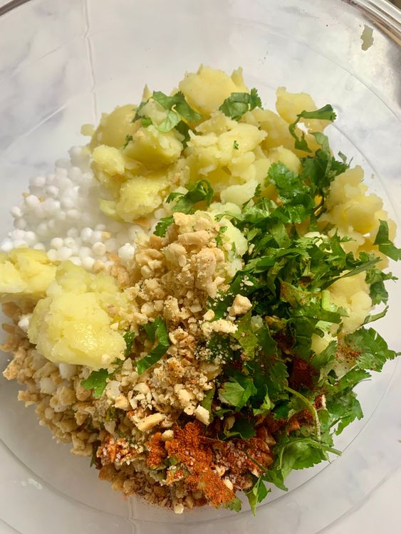 Step 2.1: In a mixing bowl, combine soaked sabudana, mashed potatoes, chopped coriander, green chillies, roasted ground peanuts, red chilli powder, and salt