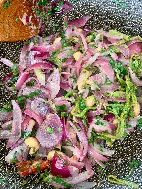 Step 4.3: Add sliced onions, coriander stems with leaves, green chillies, and cashews; sauté for 2–3 minutes until onions soften