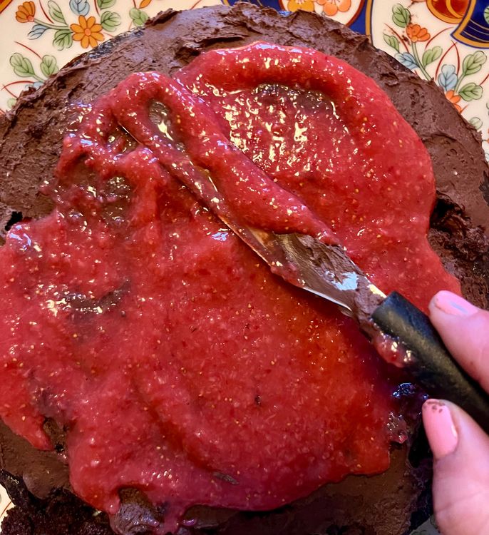 Step 3.1: Once you’ve covered the top, take out the reserved pureed strawberries and spread over the icing, but leaving some space along the edges so it doesn’t spill over