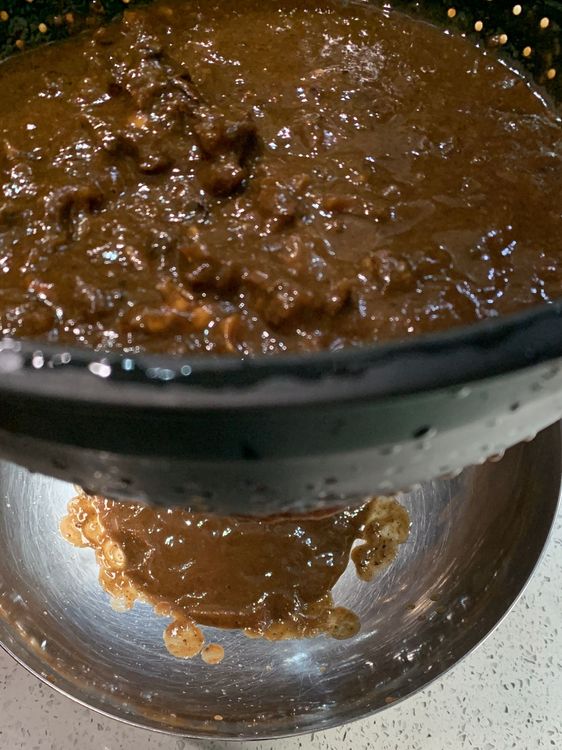 Step 1.1: Strain the mixture through a fine-mesh sieve, pressing the tamarind pulp with a spoon to extract as much liquid as possible