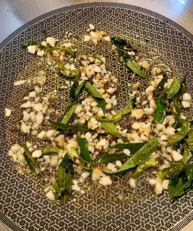 Step 3.1: Add asafoetida, ginger, green chillies and grated coconut, curry leaves to the wok