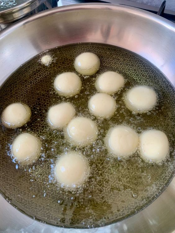 Step 3.1: Once the oil is ready, carefully slide in the jamun balls, a few at a time