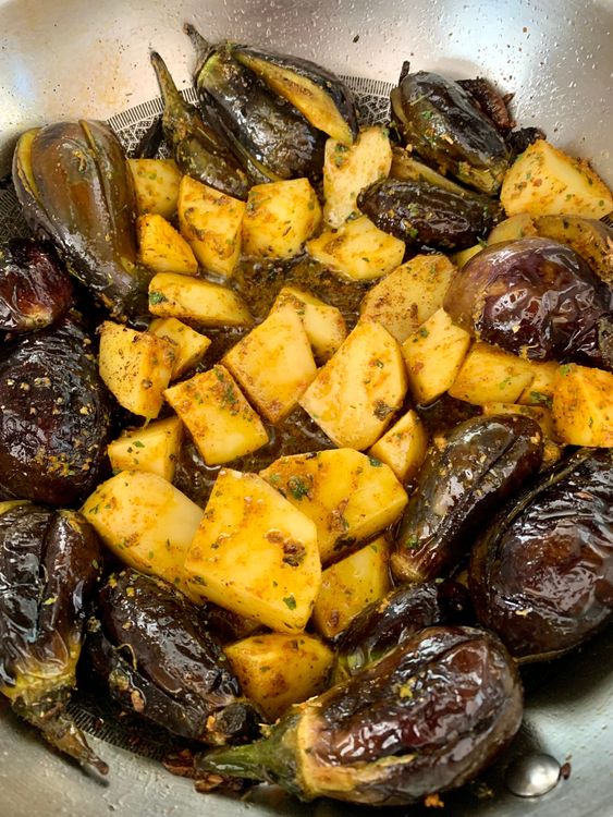 Step 3.1: Gently push the brinjals to the sides of the pan and add the potatoes in the centre