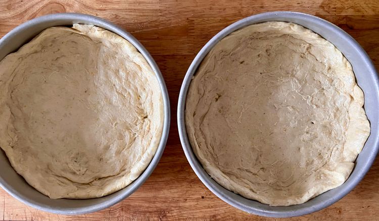 Step 1.2: Take out two 9 inch cake pans, put a drop of olive oil in each of them, and with your fingers, spread the oil all over the inside of the pan