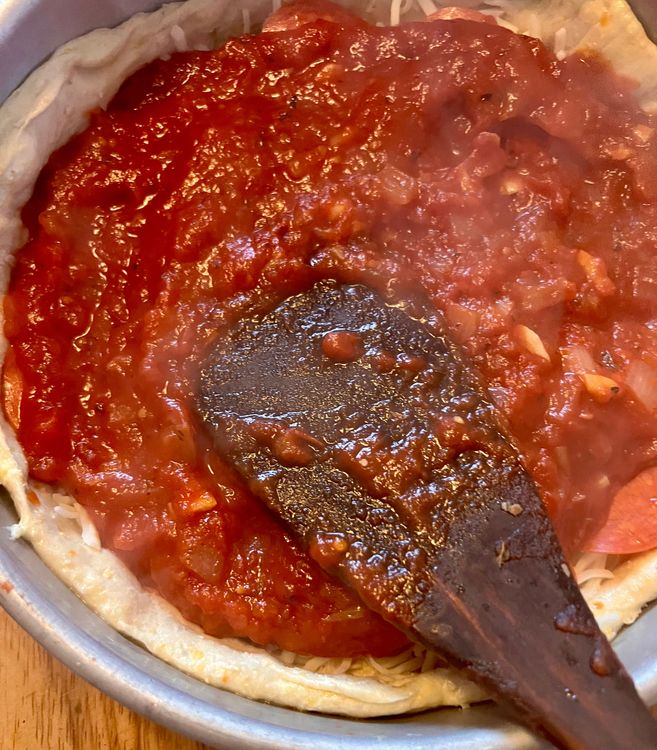 Step 1.1: Once you're satisfied with your topping selection, spread about a cup's worth of sauce on top of everything
