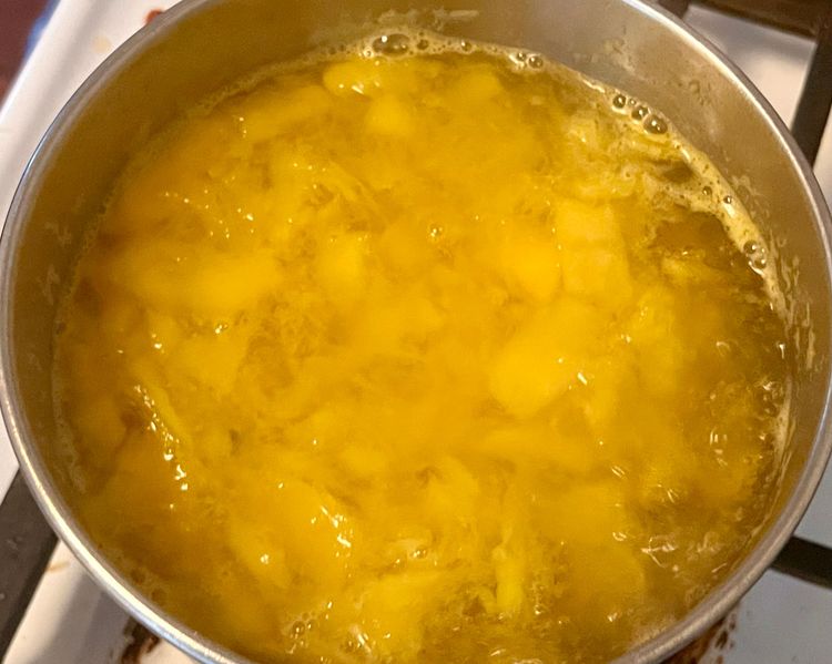 Step 1.1: Taking a potato masher, mash the mangoes in the sauce pan