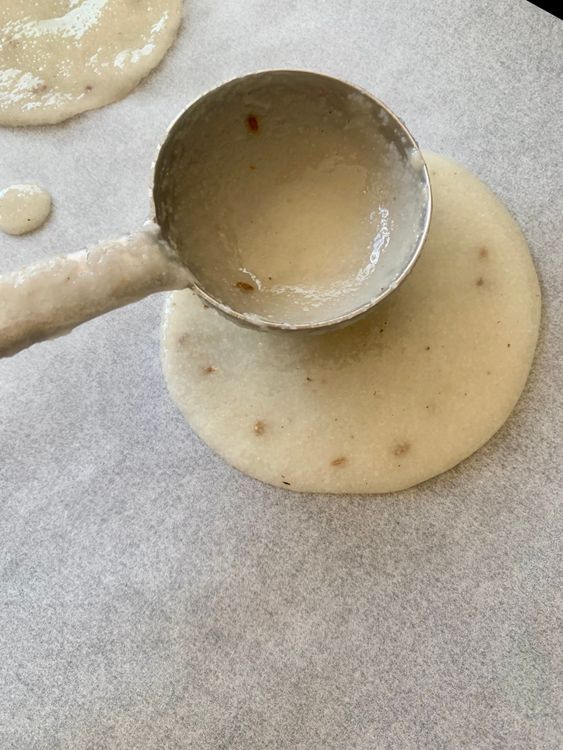 Step 1.1: Take a little of the suji mix and spread it thinly on the prepared surface