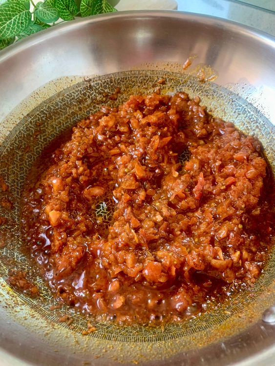 Step 2.1: Stir in Kashmiri red chilli powder, then quickly add the ground tomatoes to prevent the spice from burning
